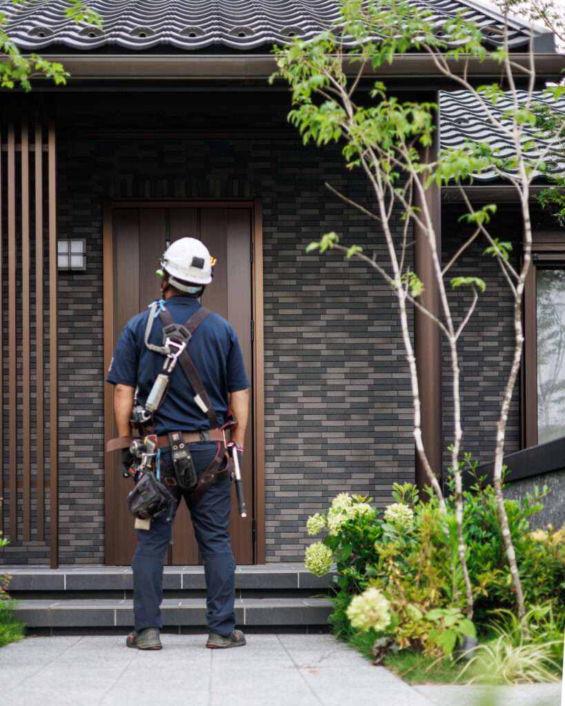 完成したセキスイハイムの住宅前に立つ施工スタッフ