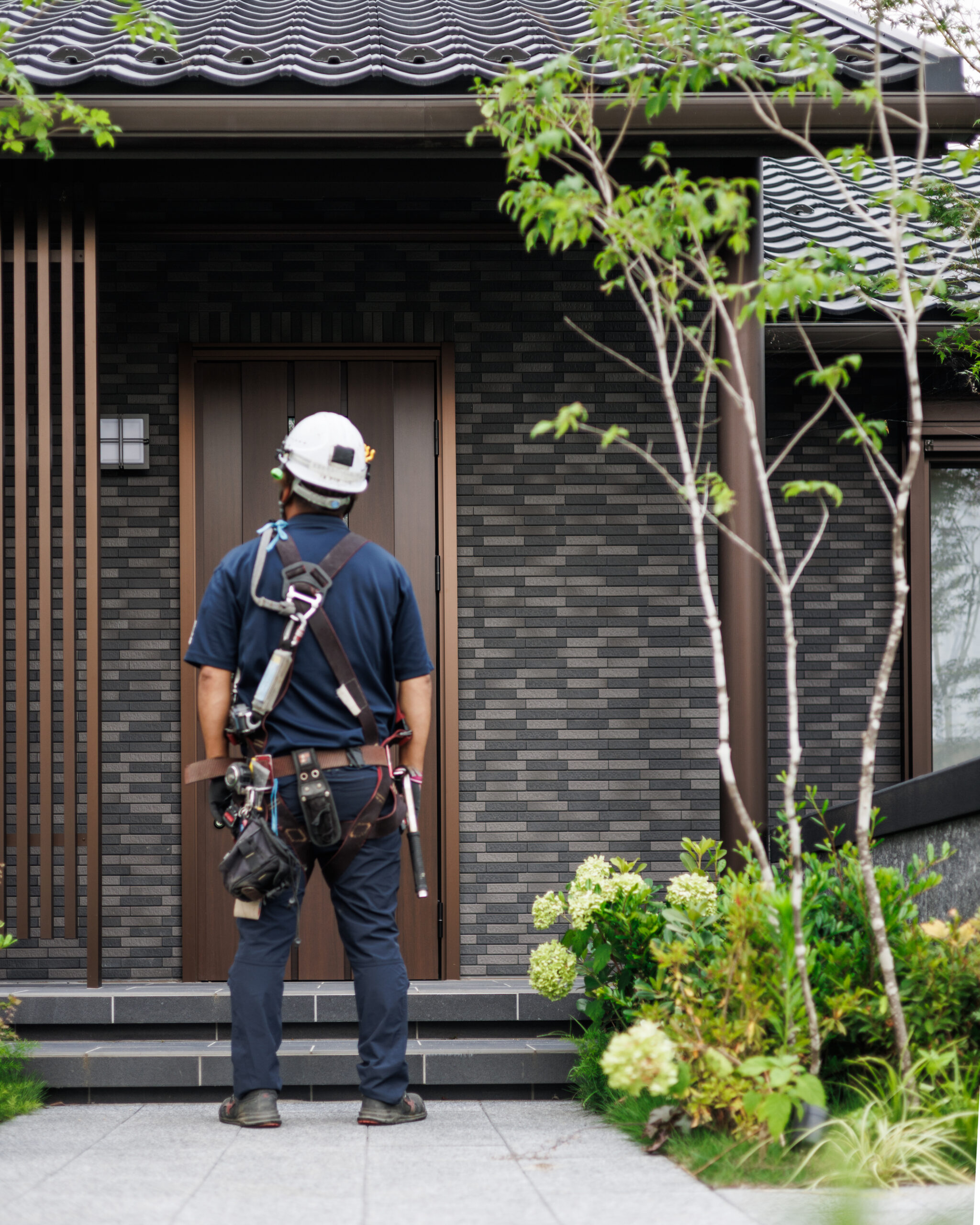 完成したセキスイハイムの住宅前に立つ施工スタッフ